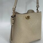 Coach Gofraj baskılı kilitli büzgülü bej çanta